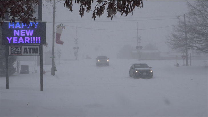 A pair of vehicles drive through snow in downtown Potter on Wednesday, Jan. 5, 2022.