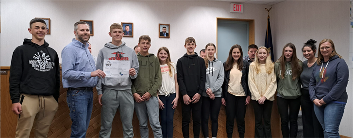 Mike Palmer, Sidney's representative with ACE, presents a $250 check to the Holy Trinity Lutheran Church youth Tuesday.
