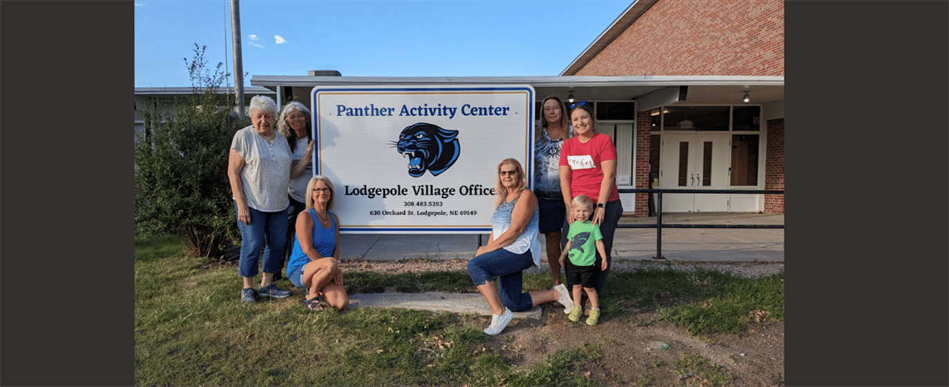 Pictured with the new Panther Activity Center sign - Janet Fox, Dana Hill (standing next to sign on the left), Toni Bruns (front left), Terry Christensen, (front right), Laurie Abrams, Trinity Oliverius and Waylon Oliverius.