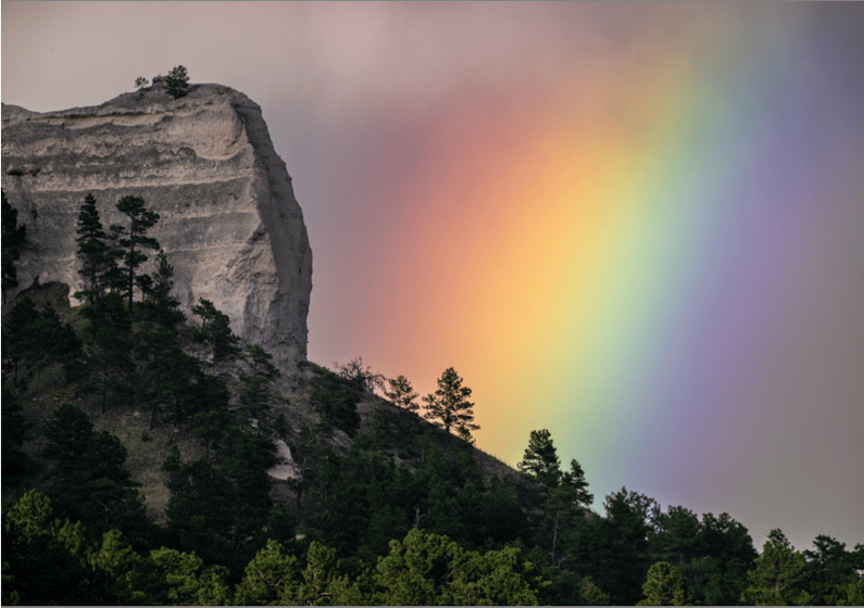 People with common vision would see the full spectrum of color in this rainbow behind Giant's Coffin Butte at Fort Robinson State Park.