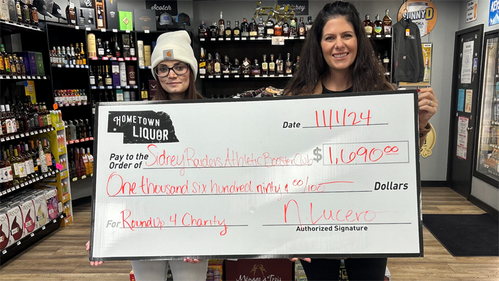 From left: Hometown Liquor's Kali Timmens presents a $1,690 to Sarah Kaiser of the Sidney Athletic Booster Club.