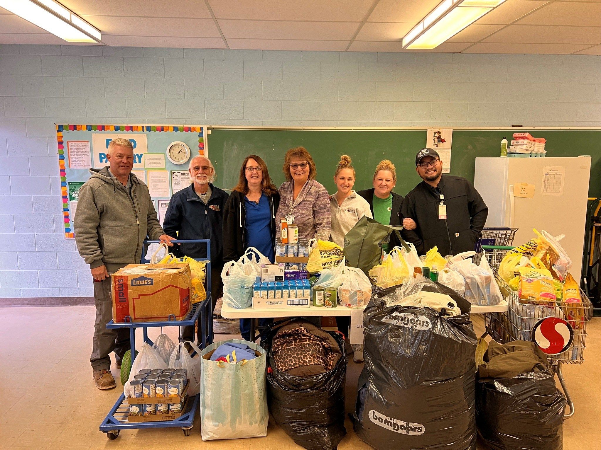 Kimball Health Services staff members stand alongside Chellie Autrey, Radiology Department Director and Kimball Food Pantry volunteer with the collection of donations.