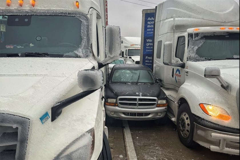 In a photo released by the Kansas Highway Patrol, a car is wedged between two trucks during icy weather Saturday, Jan. 4, 2024, in Salina, Kansas.
