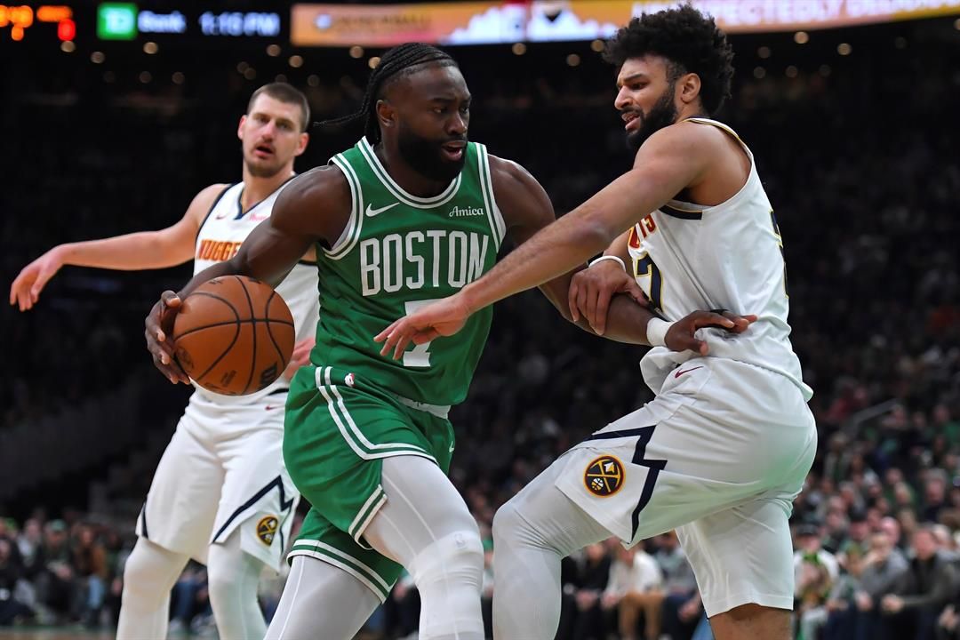 Boston Celtics guard Jaylen Brown, center, drives past Denver Nuggets guard Jamal Murray, right, in the first half of an NBA basketball game, Sunday, March 2, 2025, in Boston.
