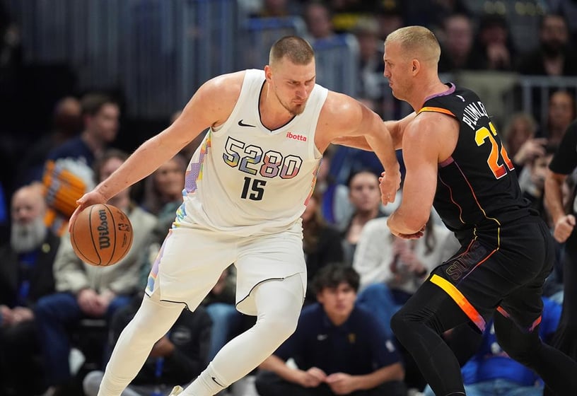 Denver Nuggets center Nikola Jokic, left, drives to the basket as Phoenix Suns center Mason Plumlee defends in the second half of an NBA basketball game Friday, March 7, 2025, in Denver. (