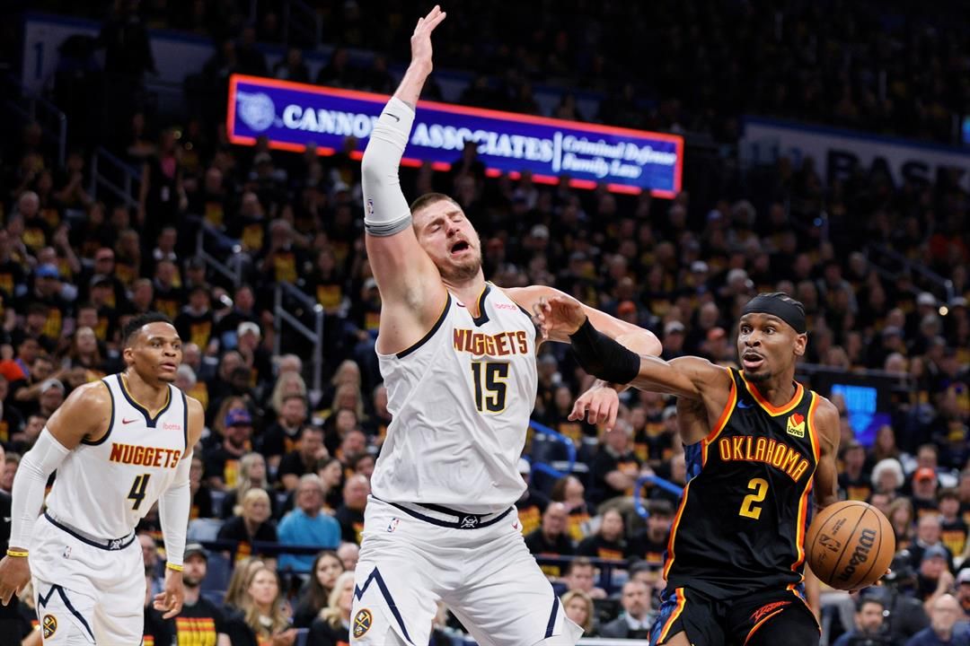 Oklahoma City Thunder's Shai Gilgeous-Alexander (2) works to the basket as Denver Nuggets' Nikola Jokic (15) and Russell Westbrook (4) defend in the second half of Game 1 of an NBA basketball second-round playoff series Monday, May 5, 2025.