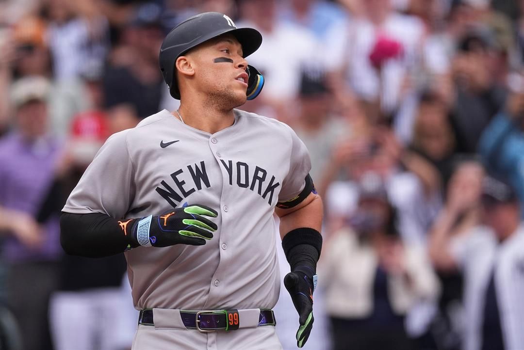 New York Yankees' Aaron Judge heads back to the dugout after touching home plate following his solo home run off Colorado Rockies starting pitcher Kyle Freeland in the first inning of a baseball game Saturday, May 24, 2025, in Denver.
