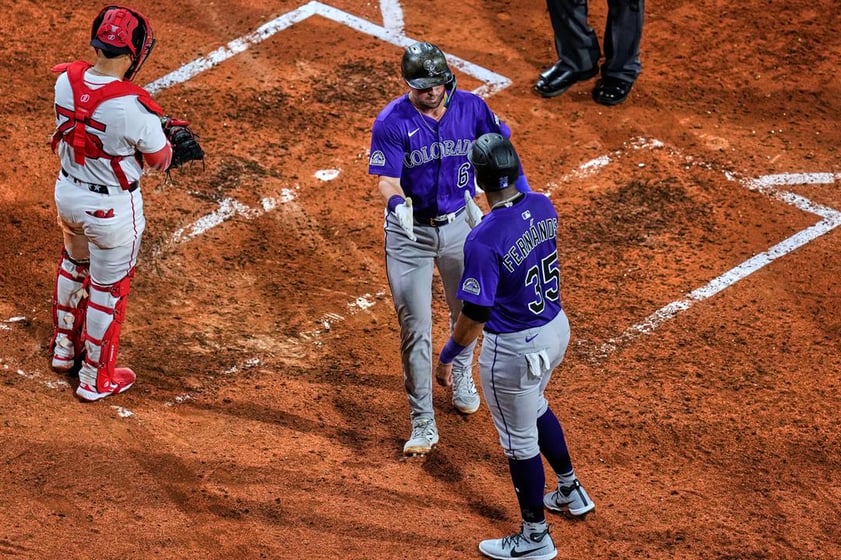Colorado Rockies' Kyle Farmer, center, is congratulated after his two-run home run against the Boston Red Sox during the eighth inning of a baseball game at Fenway Park, Wednesday, July 9, 2025, in Boston.