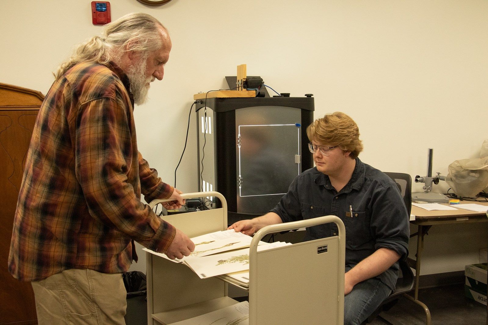 Chadron State College's High Plains Herbarium Director Steve Rolfsmeier, left, reviews plant specimens with senior Colton Rosane of S.D., in the Math Science Center of Innovative Learning on March 28, 2025.