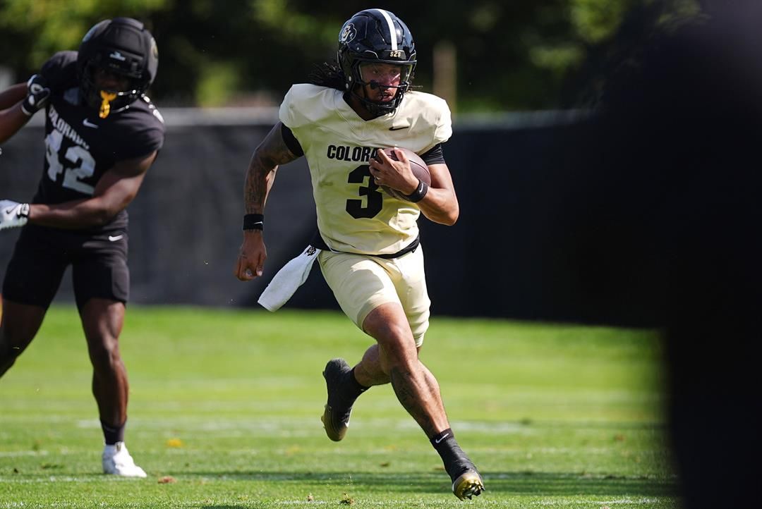 Colorado quarterback Kaidon Salter, front, runs for a gain past linebacker Jeremiah Brown during an NCAA college football practice, Thursday, Aug. 14, 2025, in Boulder, Colo.