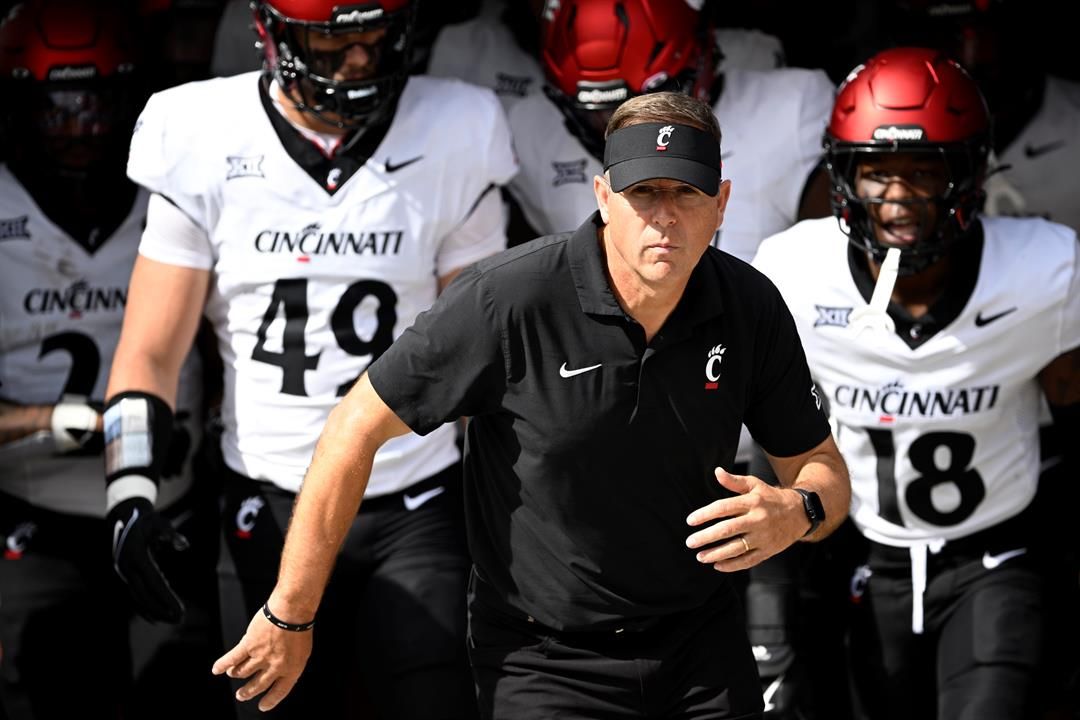 Cincinnati head coach Scott Satterfield, center, leads the team onto the field before an NCAA college football game against Central Florida, Oct. 12, 2024, in Orlando, Fla.
