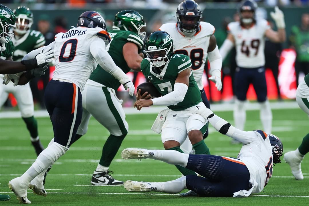 New York Jets quarterback Justin Fields, center, is sacked by Denver Broncos linebackers Jonathon Cooper, left, and Alex Singleton in the second half of an NFL football game Sunday, Oct. 12, 2025, in London.