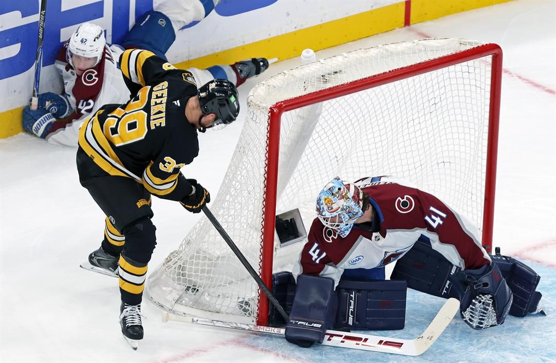 Boston Bruins forward Morgan Geekie stuffs the puck past Colorado Avalanche goalie Scott Wedgewood to score with five seconds remaining in the second period as Colorado defenseman Josh Manson watches in the background during an NHL hockey game on Oct. 25.