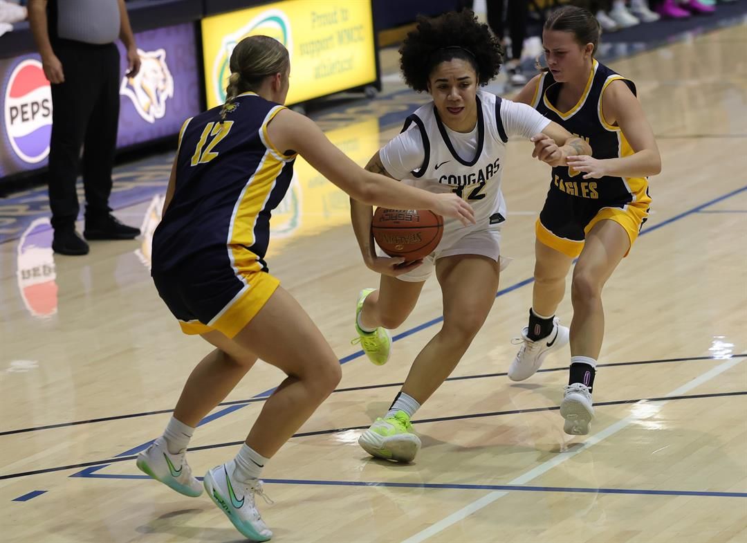 WNCC's Ella Cresty-Carty drives to the bucket through the middle of two LCCC defenders on Sunday.
