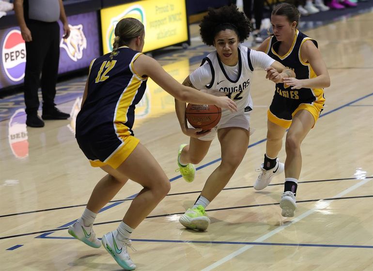 WNCC's Ella Cresty-Carty drives to the bucket through the middle of two LCCC defenders on Sunday.