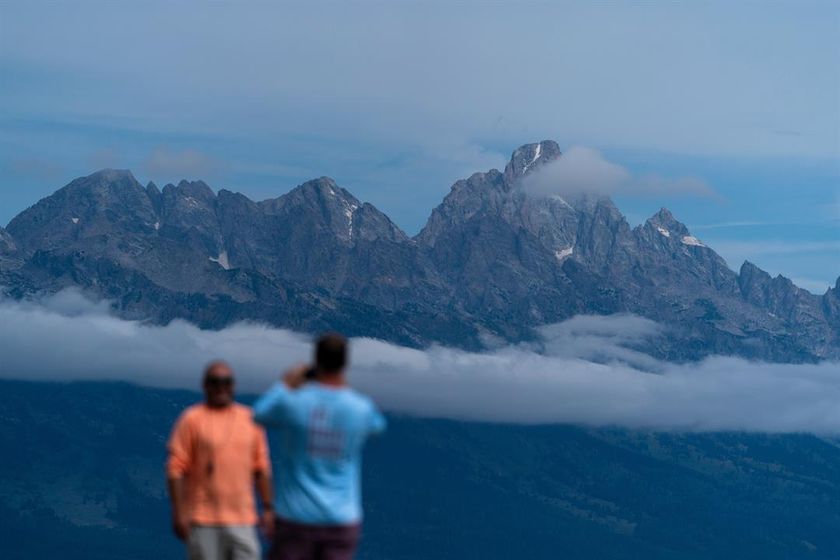 Tourists take photos in Grand Teton National Park, Wyo., Aug. 14, 2022.